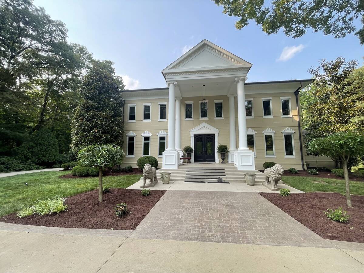 Historic estate front entrance with columns and manicured landscape